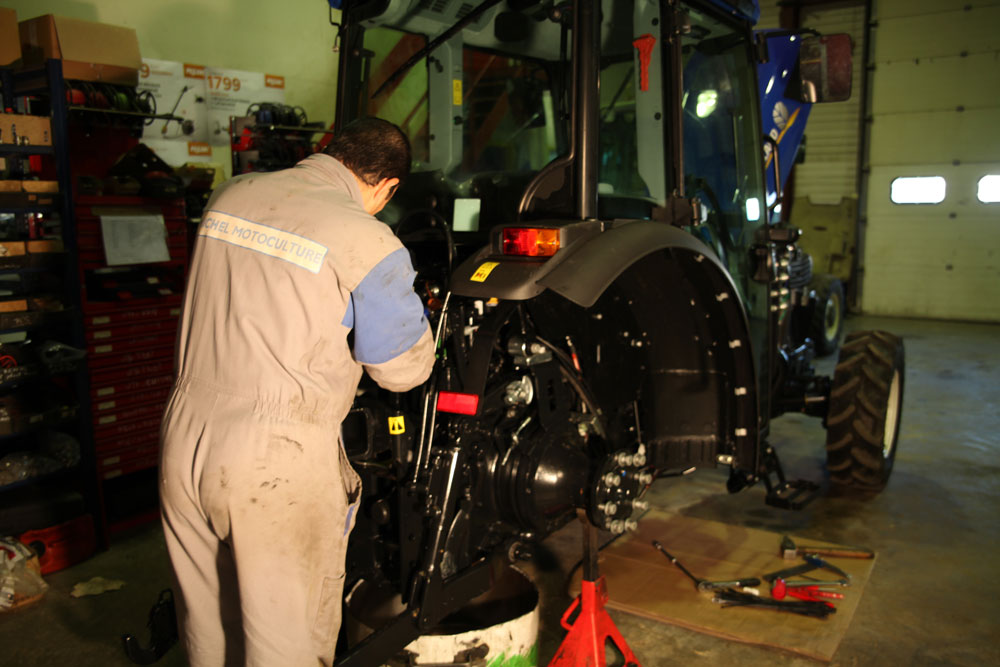 Mécanicien intervenant sur le moteur d'un tracteur